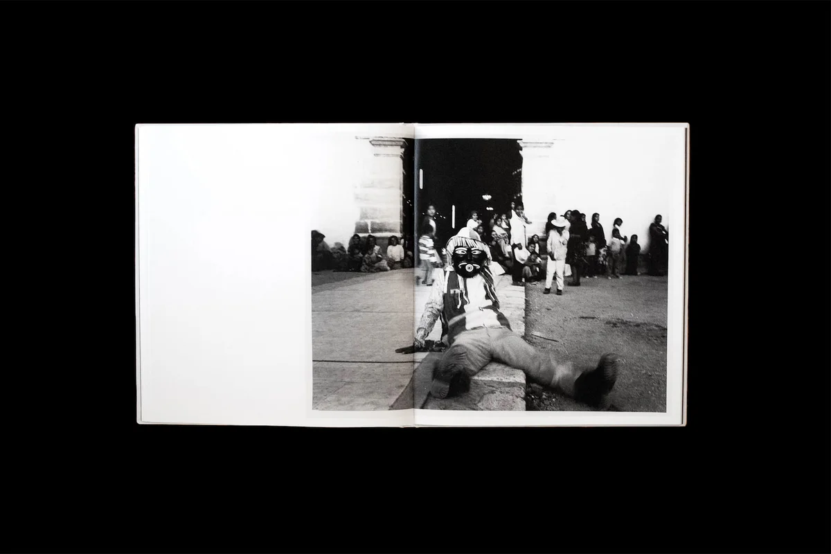 Full spread showing a masked figure at a village festival