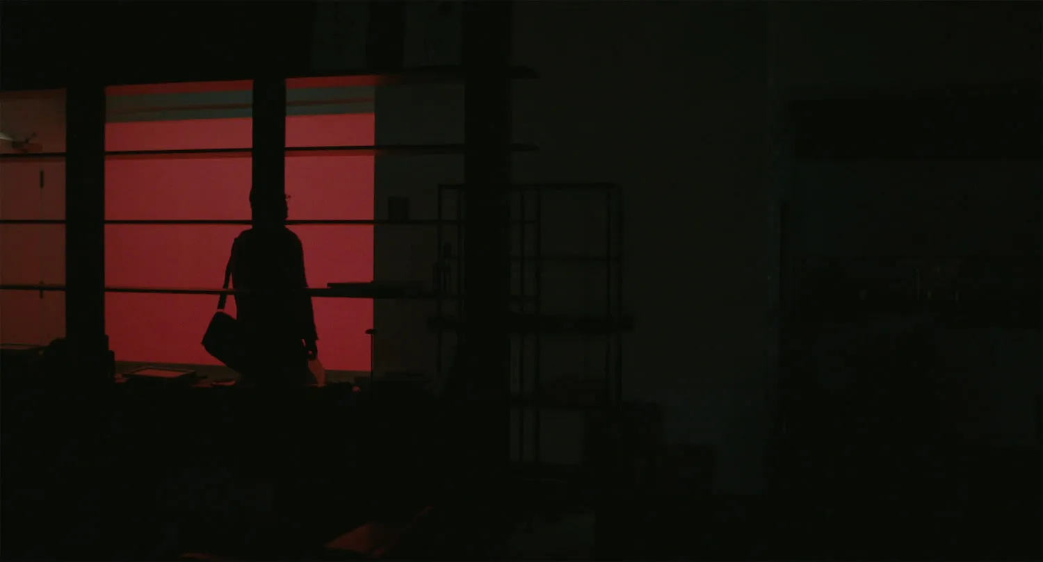 Person in red-lit room looking at phone